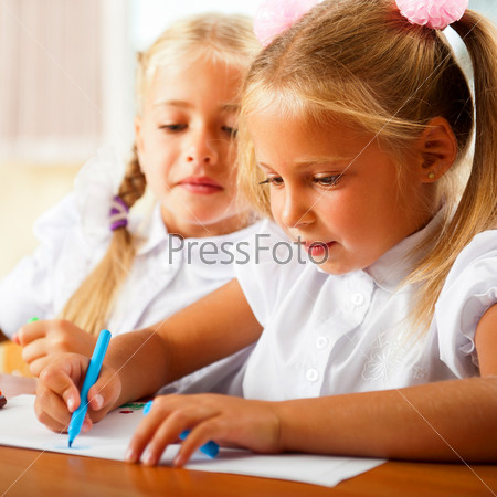 Little girls drawing pictures and writing letters to Santa Claus to get christmas gifts. Indoor at classroom