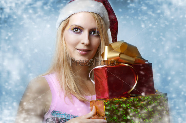 Christmas concept. Beauty portrait happy woman model holding two gift  boxes in hands and smile  in santa claus hat
