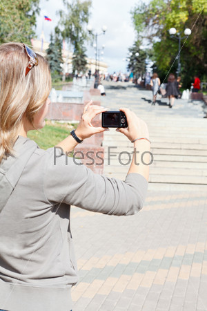 Young beautiful woman photographing city\'s attractions, outdoors