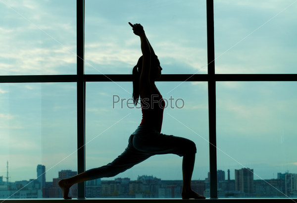 Silhouette of sporty girl doing physical exercise