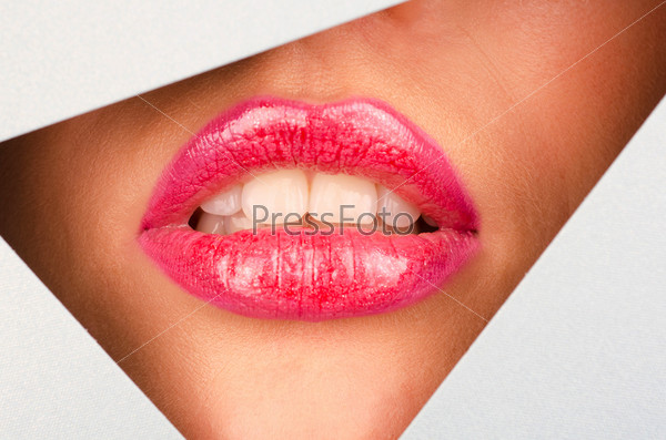 Beautiful female lips closeup behind silver paper background