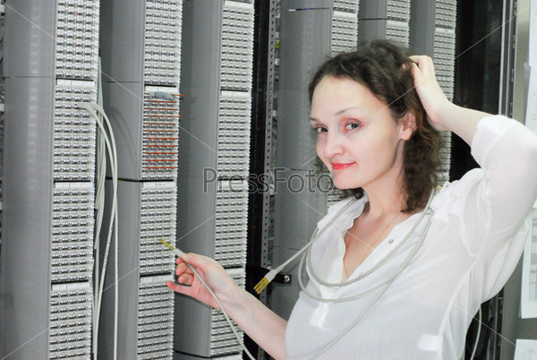 Женщина-оператор на технической площадке мобильного коммутационного центра подключения сотовых телефонов