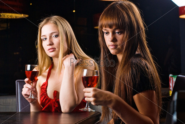 Young woman drinking red wine in bar
