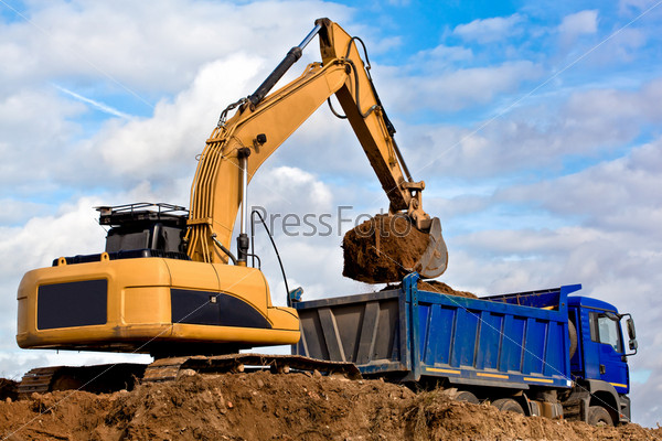 Dozer Backhoe loading soil or sand into Tip Truck
