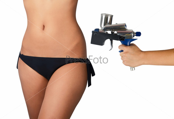 perfect woman body closeup and hand with tanning gun for quick tanning on a white background