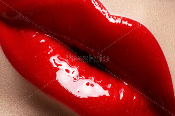 Close-up of woman\'s lips with bright fashion red glossy make-up