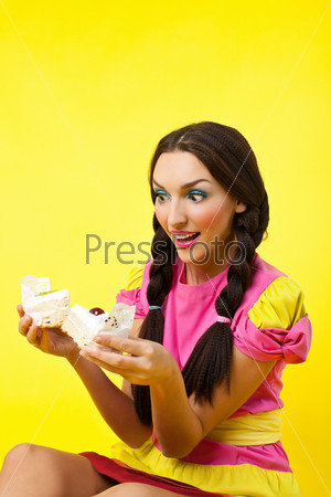 Happy girl take two cake - pin-up doll costume on yellow background