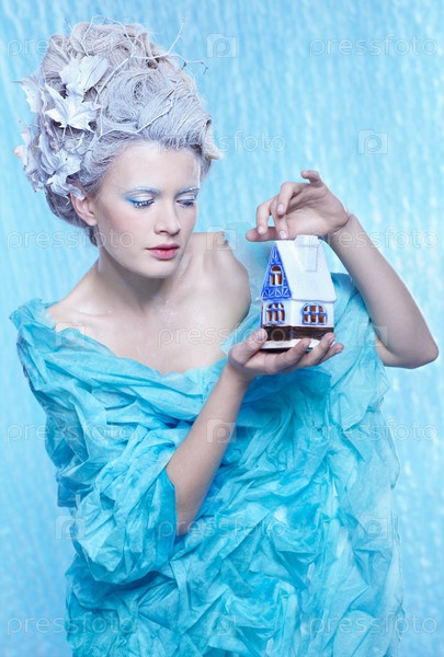 fantasy portrait of beautiful young woman imaging ice fairy on frozen blue with toy house