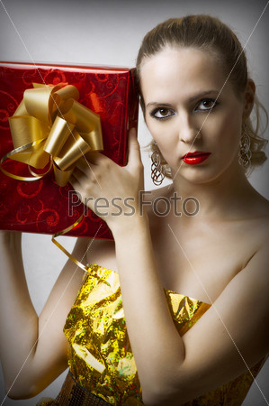 Портрет молодой гламурной девушки держащей подарок в руках