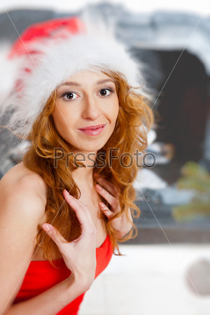 Christmas woman near a Christmas tree very excited while sitting near Christmas tree and fireplace at home
