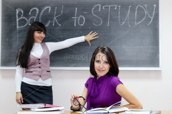Преподаватель и ученица на фоне классной доски