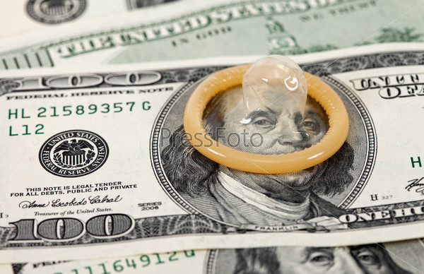 Condom on the US dollars bills, stock photo