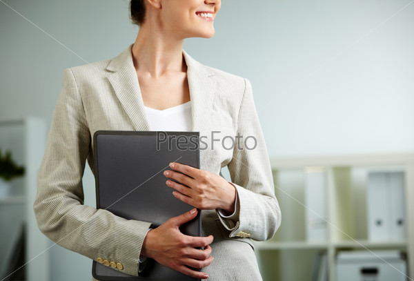 Close-up of businesswoman holding folder in hands, stock photo
