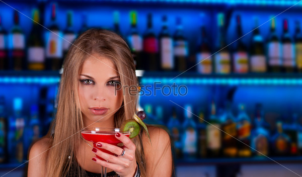 Girl with cocktail on bar counter background, stock photo