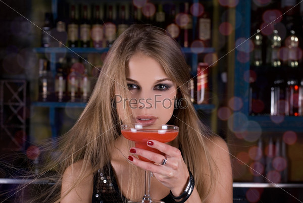 Girl with cocktail on dancing people background