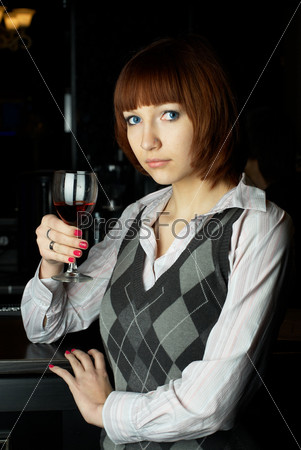 Young woman drinking red wine in bar