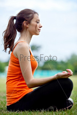 Relaxed thin woman practicing yoga at the park