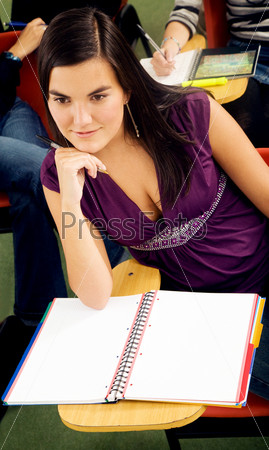 female university student in a classroom at her desk