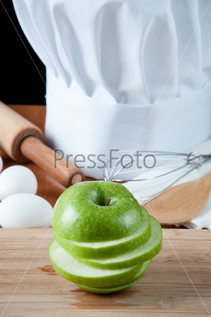 Fresh green apple, chef\'s hat and different kitchen utensils