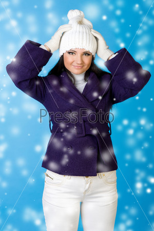 Portrait of the beautiful woman in winter fashion. Studio photo with snowflake imitation.