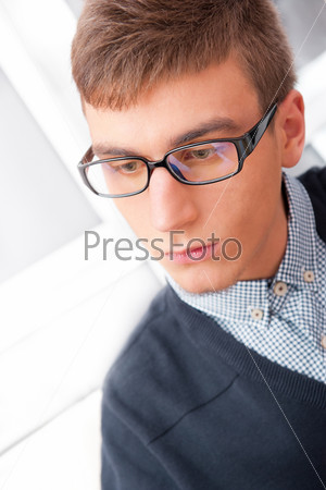 A university college student or casual good looking man wearing glasses portrait. Looking away