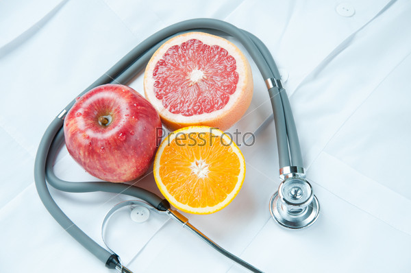 Healthy life-style concept with fresh fruits and stethoscope on doctor\'s smock