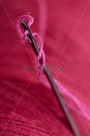 Extreme macro view of needle and red thread