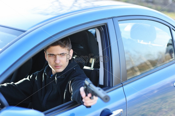 Gunman in car holding gun with silencer