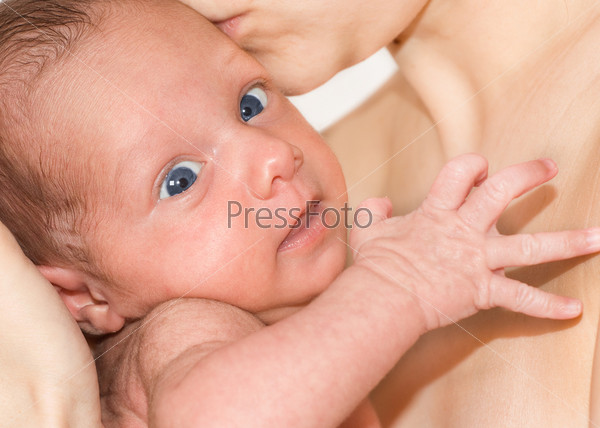 Mother holds baby with blue eyes on his hands