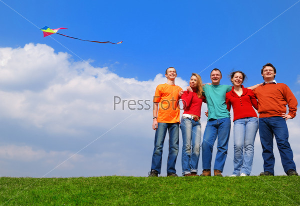 Group of people smiling against blue sky