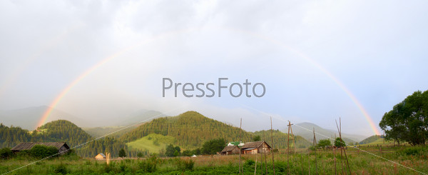 rainbow over mountain village after the rain
