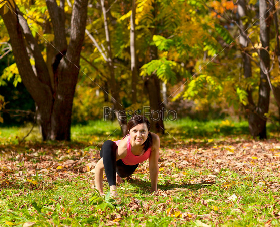 Woman exercises in the autumn forest yoga