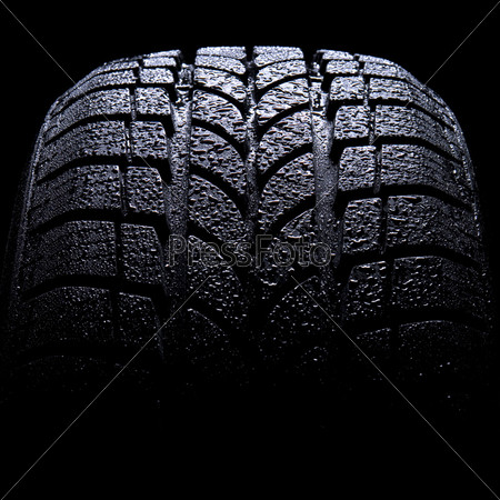 Автомобильная шина на черном фоне