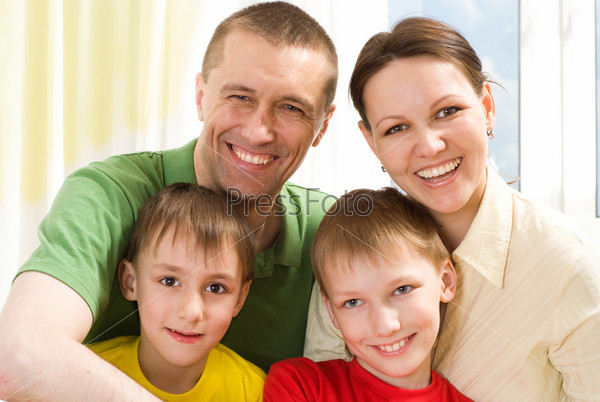 portrait of a happy family of four on a light background