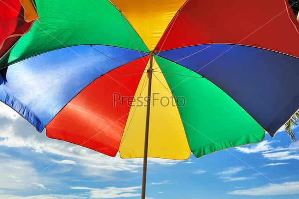 Красочный зонтик на пляже на фоне неба. Крупный план