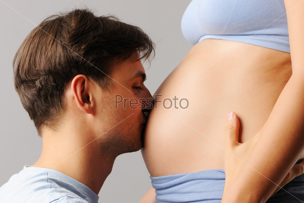 Happy father kissing his wife\'s belly
