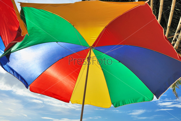 Красочный зонтик на пляже на фоне неба. Крупный план