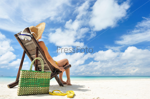 Woman on a tropical beach with hat