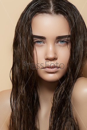 Beautiful young model with long wet hair, light makeup, strong eyebrows and perfect purity skin. Fresh summer look with damp beach hairstyle
