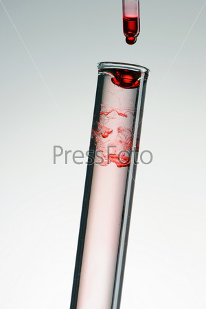 Test tube with red reagent and pipette close-up