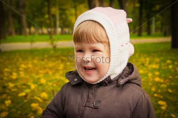 The small child walks in autumn park, stock photo