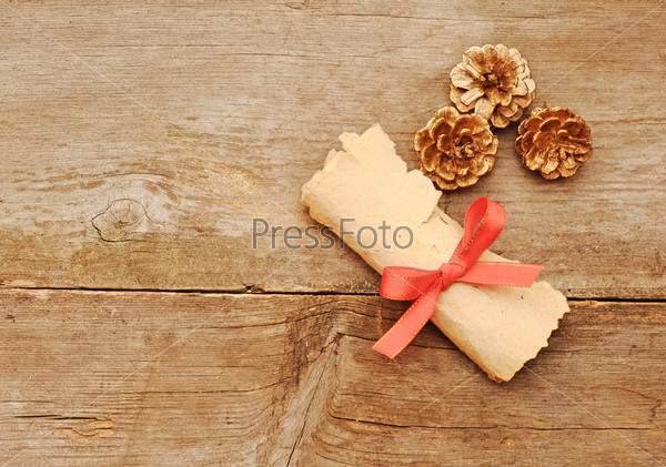vintage paper roll with gold cones on old wood background