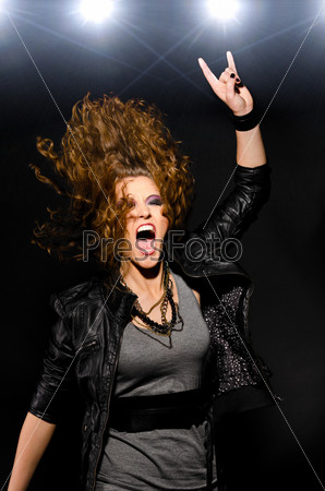 Девушка танцует под рок-музыку на черном фоне
