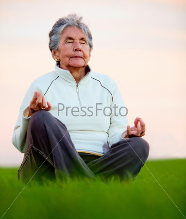 Elder woman doing yoga exercises outdoors - fitness concepts
