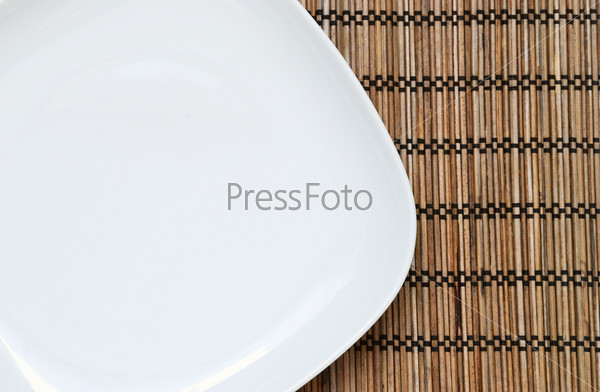 Empty plate on the bamboo napkin, top view