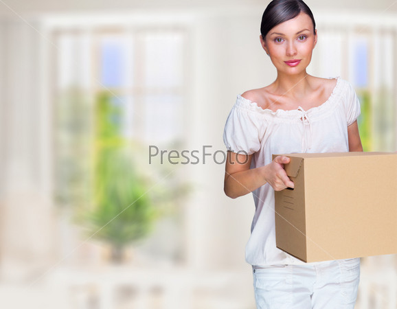 Smiling woman at her home holding boxes. She is Moving at her new home. Mortgage concept