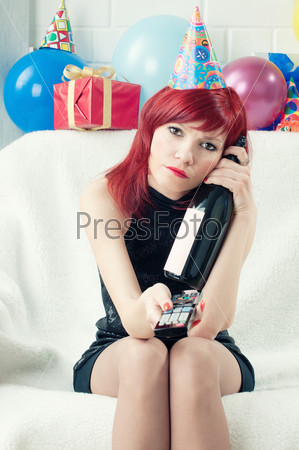 Dull birthday: bored party woman watching TV at home