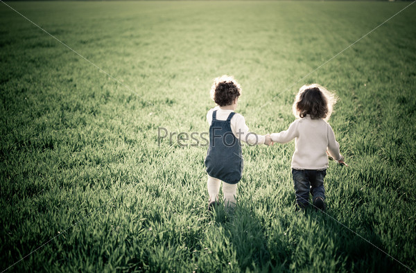 Двое детей на зеленом весеннем поле