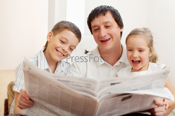 Отец и дети читают газету
