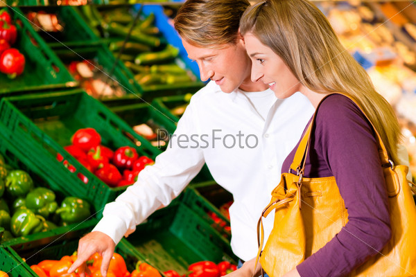 Счастливая пара выбирает продукты в супермаркете
